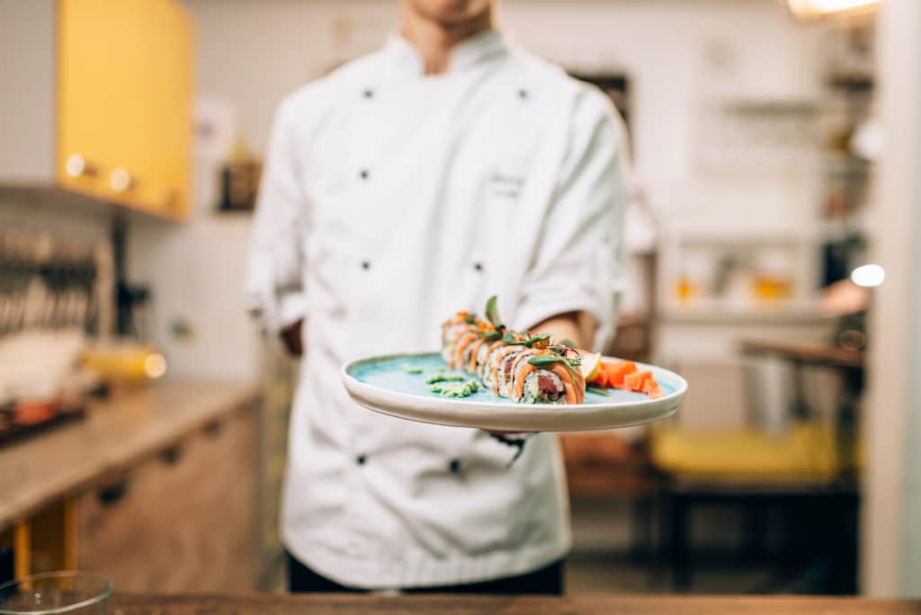 male chef hold sushi rolls plate japanese cuisine preparation process | B.Gordon Builders